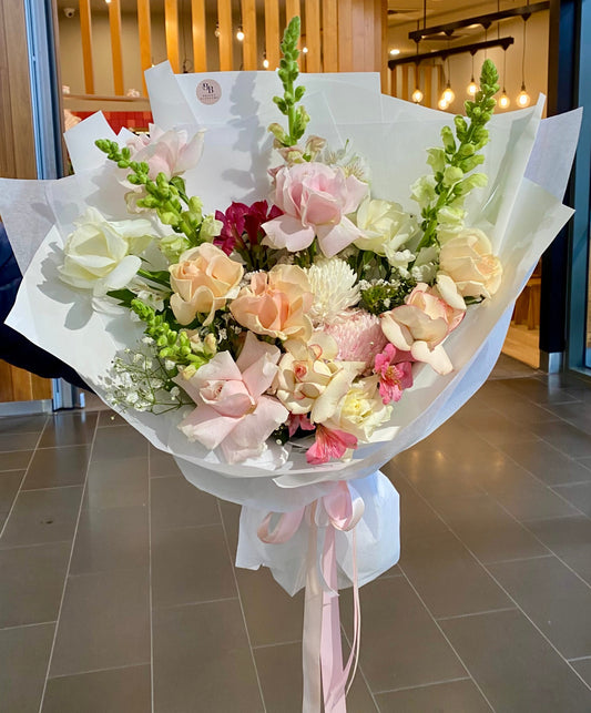 Pastel Reflexed Rose Bouquet featuring premium pastel roses carefully reflexed for a full open bloom, arranged with soft seasonal foliage for a dreamy, elegant finish.