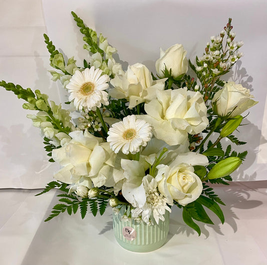 White Serenity Vase featuring fresh white blooms arranged in a modern round ribbed vase, creating a soft and elegant all‑white display.