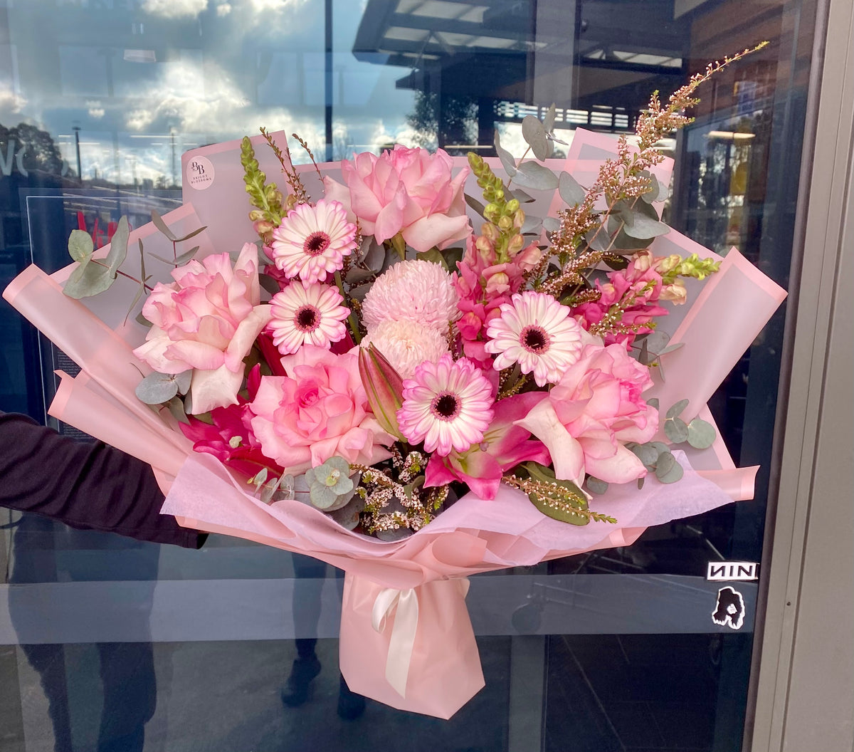 Pink Elegance Bouquet featuring roses, gerberas, snapdragons, oriental lilies and chrysanthemum mums arranged with soft complementary seasonal blooms.