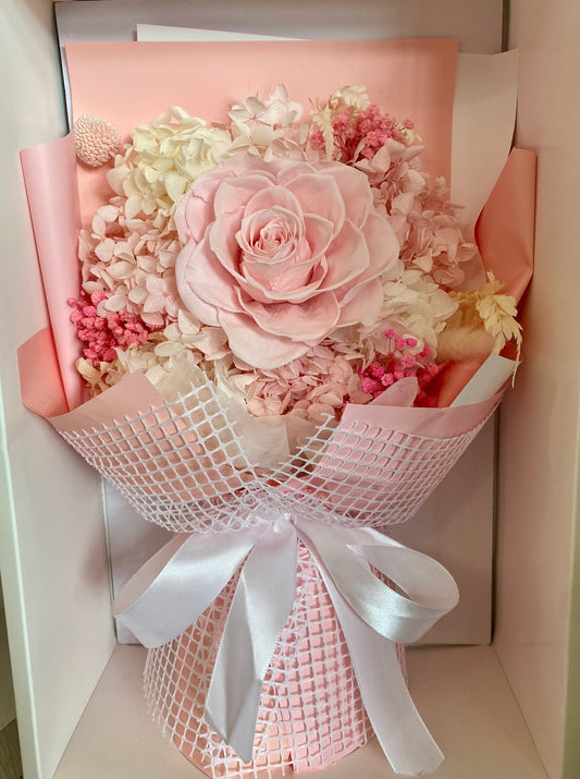Everlasting preserved flower bouquet in soft pink tones featuring long‑lasting dried blooms arranged in a clear display box.