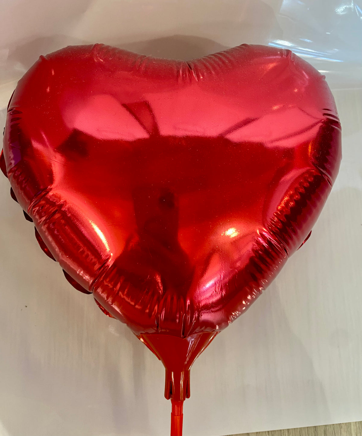 Red heart‑shaped foil balloon with a glossy love‑heart design, approx. 22cm in diameter.