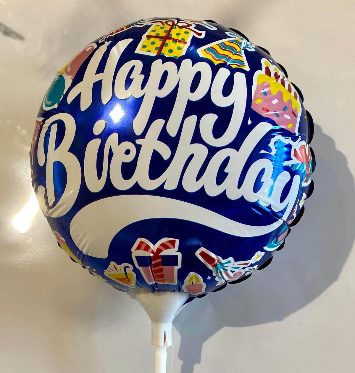 Round Happy Birthday foil balloon with colourful party design, approx. 22cm in diameter.