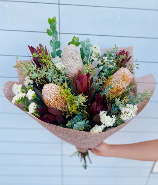 Native Elegance Bouquet featuring proteas, leucadendrons, banksias and gum foliage arranged in a textured, earthy native flower bouquet