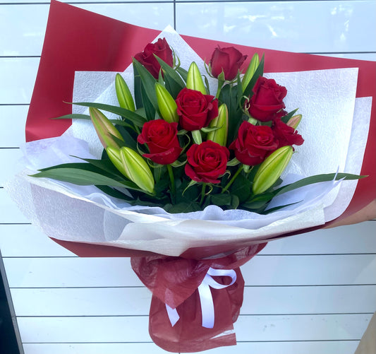 Premium long‑stem roses and fresh Oriental lilies arranged in a classic, elegant bouquet with soft complementary foliage